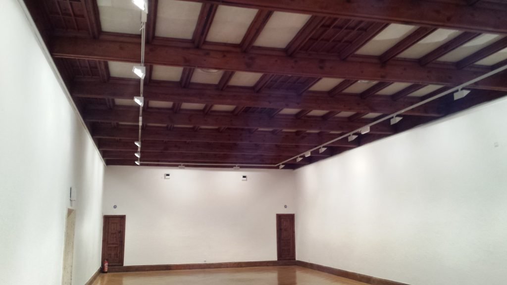 Sala con techo de vigas de madera y paredes pintadas en blanco – J.C. Sandín, pintura y pladur