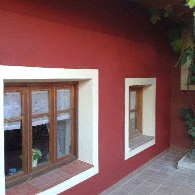 Fachada pintada en rojo con marcos de ventana en blanco – J.C. Sandín, pintura y pladur